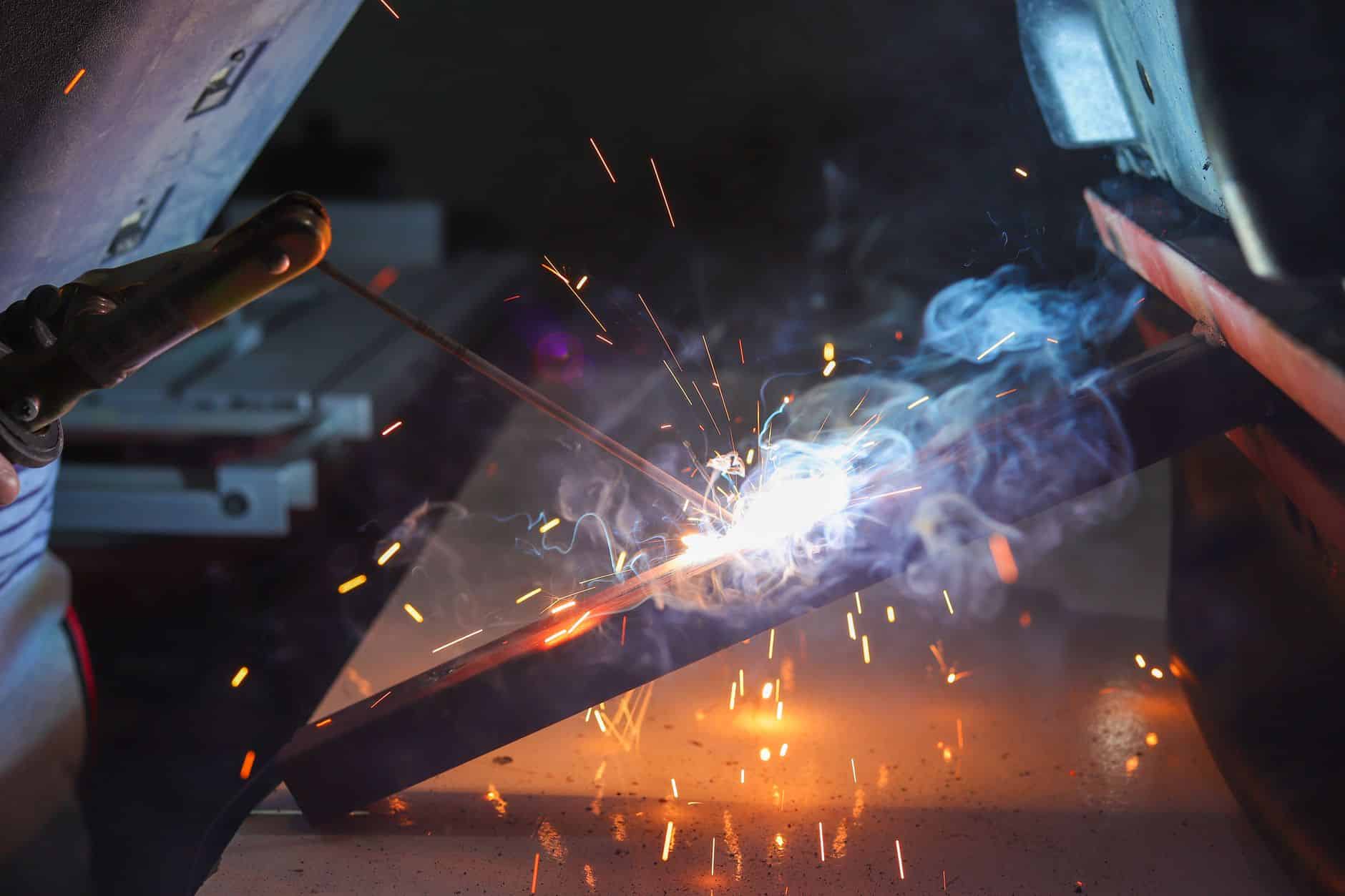 Welding robot producing spatter near exposed cable routing