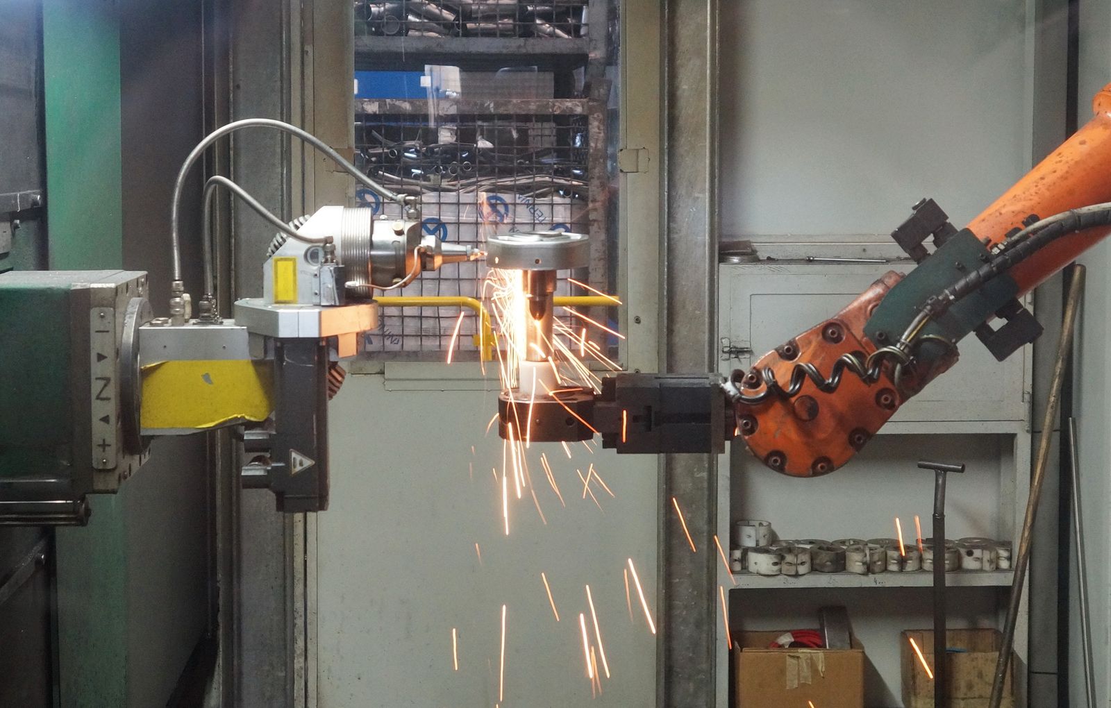 Welding robot arm producing spatter that requires spatter-resistant robot sleeve protection