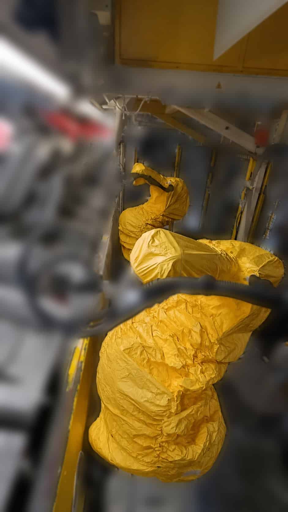Yellow RCC protective covers fitted over industrial robot arms on a production line